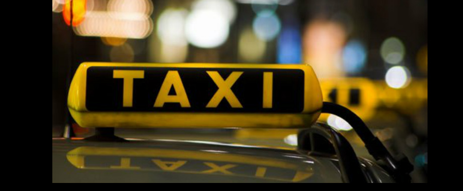 Yellow taxi sign at night in Ohrid